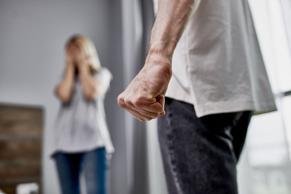 Man clenching a fist with woman in background